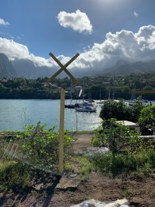 anchorage marker in foreground a post with an 'x' on top and the boats at anchor behind