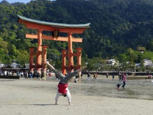 Alene doing a cartwheel in front of a Japanese monument