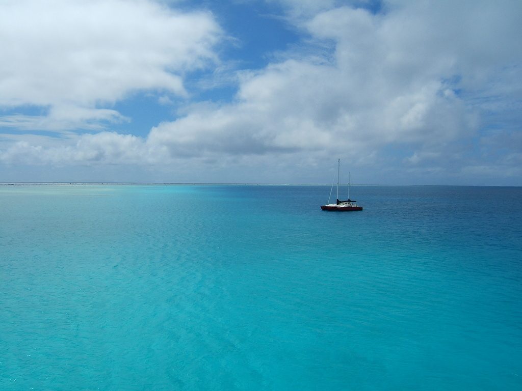 Aerial photo of the yacht Migration anchored in clear turquoise water at Minerva Reef